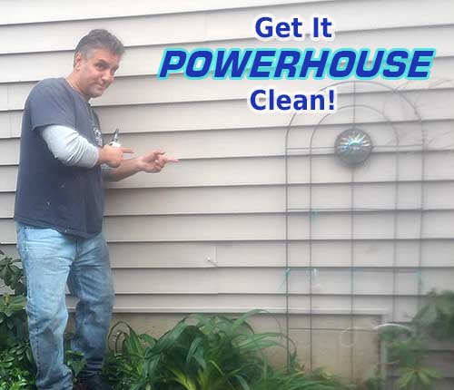 vinyl siding after soft washing Photo of Powerhouse Pete pointing at freshly cleaned siding with text that says get it Powerhouse clean!