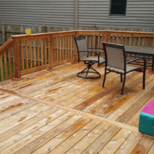 Photo of a large deck with patio furniture with deck being recently soft washed and restored
