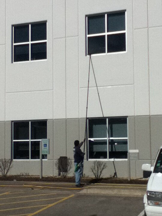 Photo of Powerhouse Pete washing a commercial building's windows