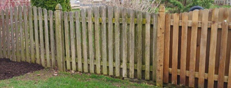 Photo of a fence half way through a wash to show cleaning comparison