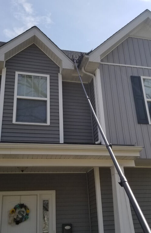 Photo of extension cleaning pole being used for gutter cleaning