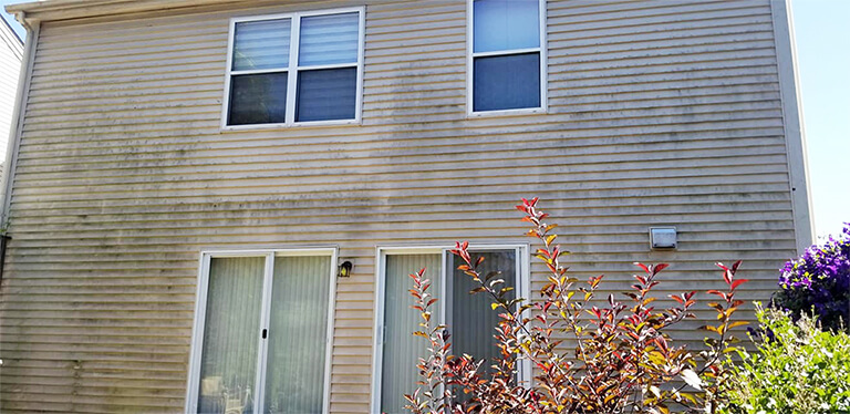 Before photo of the back of a home with vinyl siding that was washed clean