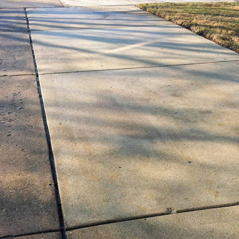 Photo of a sidewalk after being power washed and showing a comparison